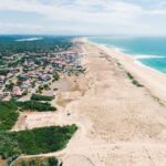 Vue aérienne par drone d’une plage landaise avec sable, dunes et océan Atlantique, idéale pour tourisme et communication visuelle