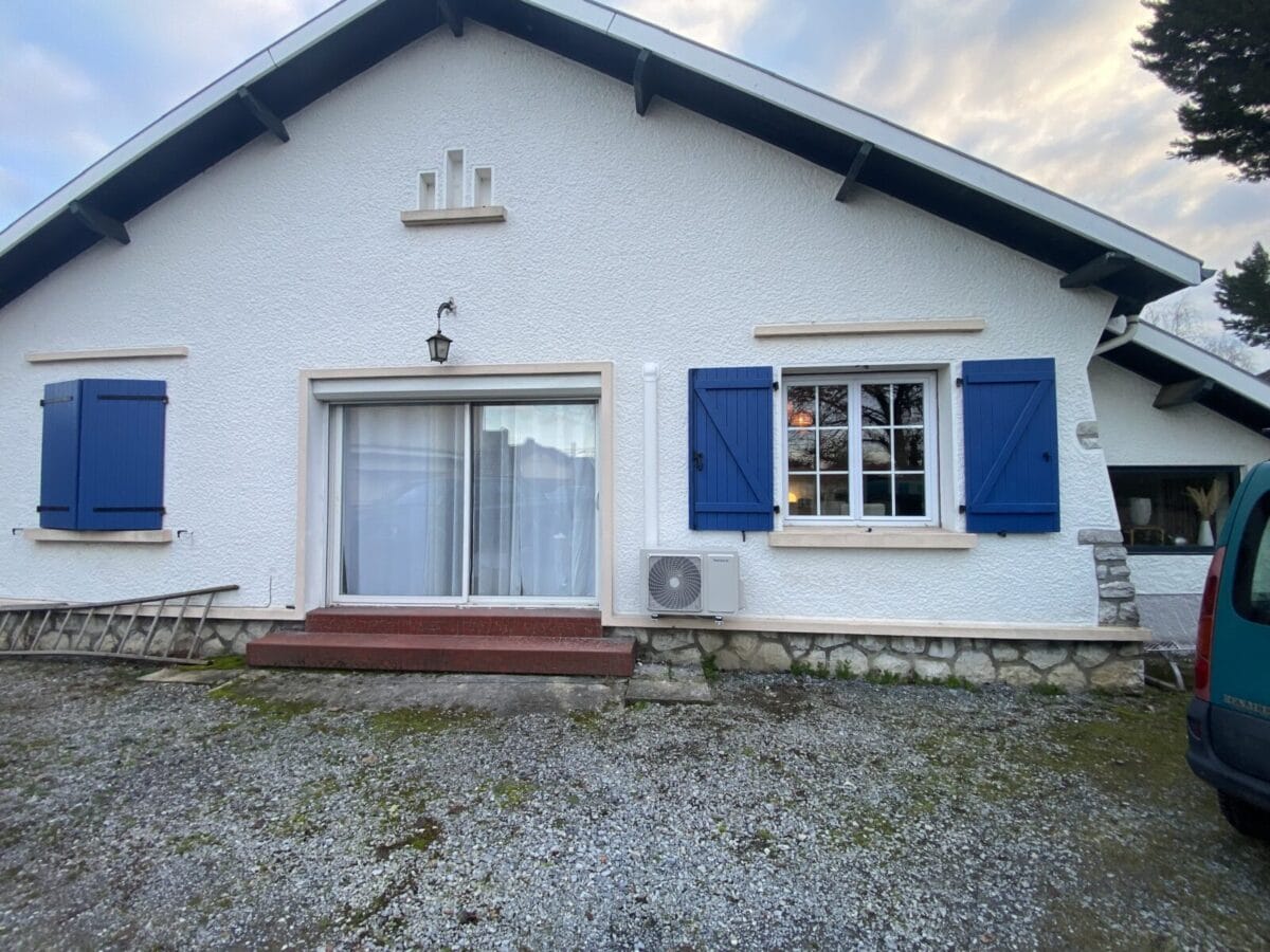Unité extérieure de climatisation posée par ETL Elec et Clim sur la façade d'une maison landaise aux volets bleus